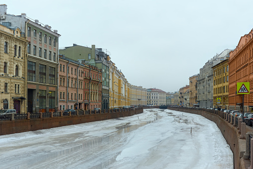 St. Petersburg, Russia - February 24, 2024. View of the frozen Moika River and the beautiful embankment. Frozen river with thawed patches of ice.