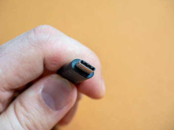 istock The usb type C cable in hand on a brown background. 2043463457