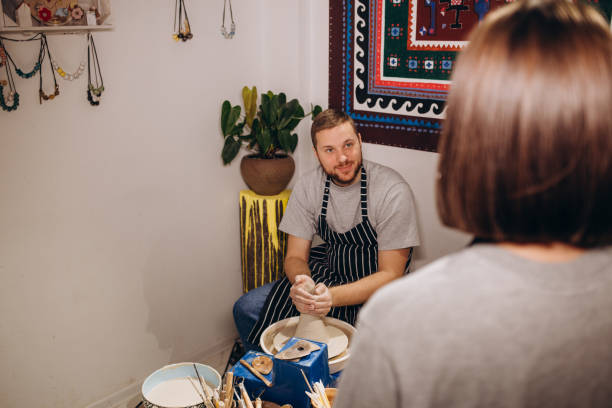 istock Mid adult couple smiling while doing creative painting on bowls in pottery workshop 2043483637