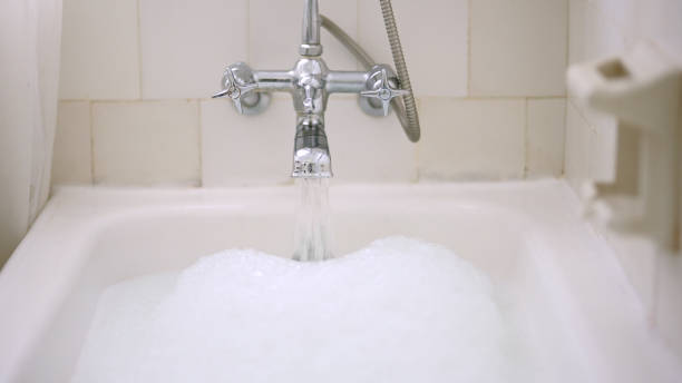 istock Faucet, water and bathtub with bubbles, foam and empty interior for hygiene, cleaning and wall background in house. Tap, flow and home for clean with soap, health and wellness for hospitality in room 2043497913