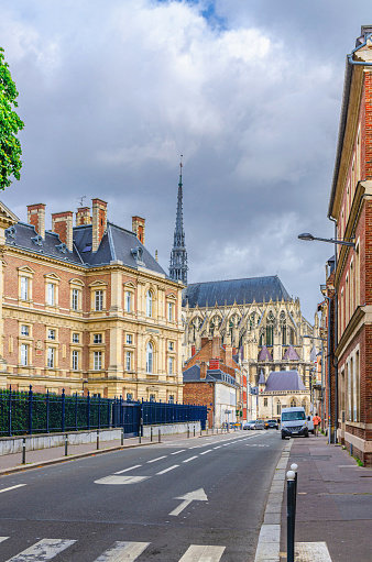 Street view of Palace of Justice Palais Cour d'Appel and Amiens Cathedral buildings in historical city centre, cloudy sky background, vertical view, Somme department, Hauts-de-France Region, France