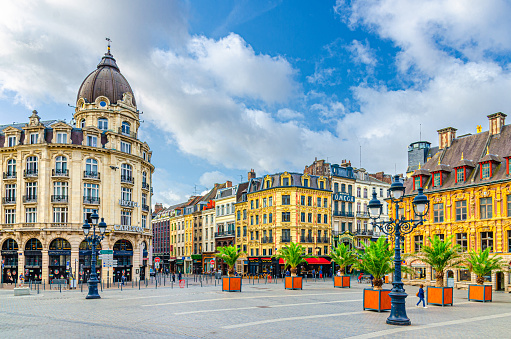 Lille, France, July 4, 2023: Place du Theatre square in Lille city historical center with Hotel Carlton, Vieille Bourse buildings, street light and palms trees French Flanders, Hauts-de-France Region