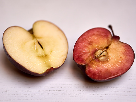 A fresh apple cut in half on a table