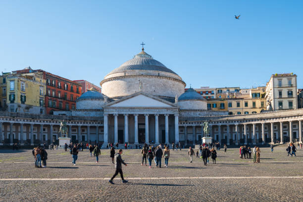 Naples, Italy - December, 18, 2022: Bustling Piazza del Plebiscito, Naples with the iconic San Francesco di Paola Basilica and walking visitors on a sunny day