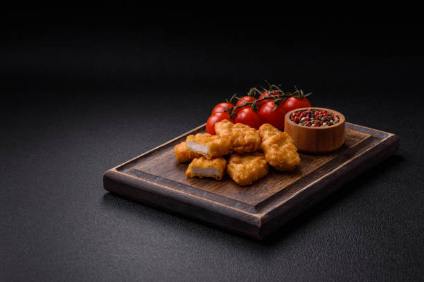 istock Delicious fresh crispy chicken nuggets on a dark concrete background 2043601499