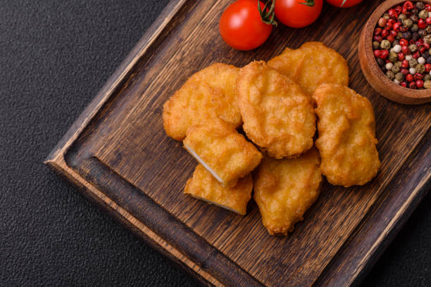 istock Delicious fresh crispy chicken nuggets on a dark concrete background 2043602259