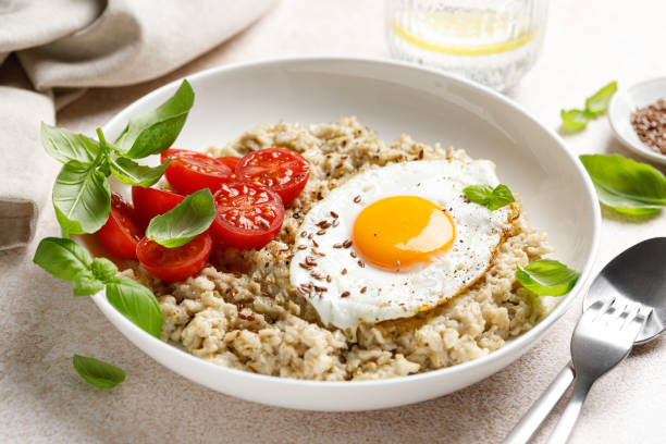 istock Oatmeal with fried sunny-side-up egg, tomatoes and basil 2043604340