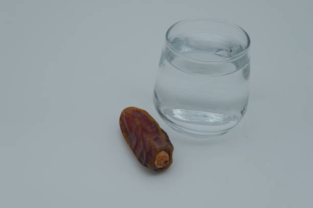 Zamzam in a small glass with dates on the side