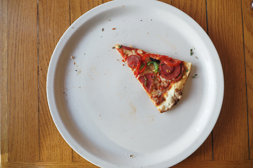 top view of a slice of pizza on a plate .