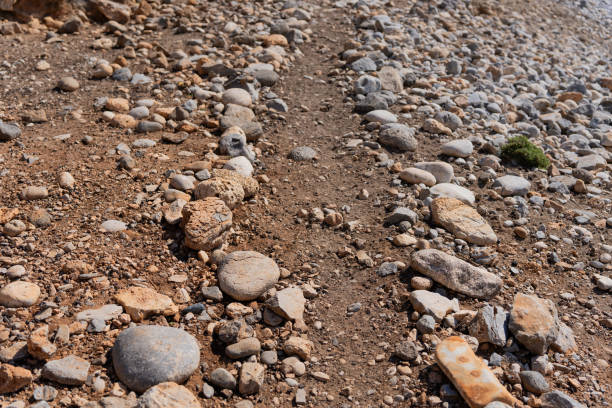 Rudimentary and simple path made with pebbles and round stones from the environment in a wild and arid area in the south of the Greek island of Crete