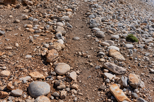 Simple and genuine path made with round stones from the path to serve as a guide for trekkers through the wild area of southern Crete in Greece