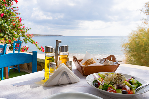 Close up of typically Greek dishes served on a Greek tavern table by the Aegean Sea on a beautiful summer day on the Greek island of Crete