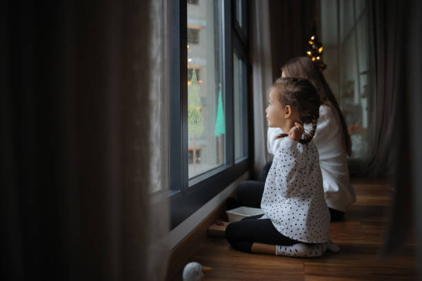 istock Young mother drawing with her little daughter on the window 2043627765