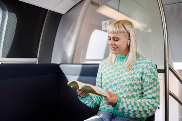 istock An urban passenger is sitting in metro train and reading a book. 2043670604