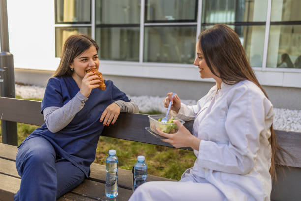 istock Nurses eating breakfast while sitting on the bench on the break. 2043684605