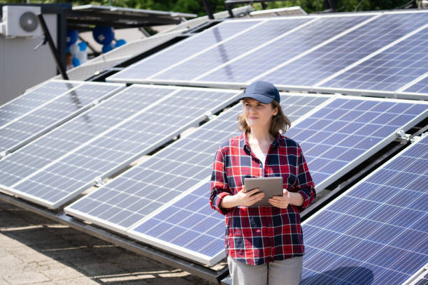 istock Woman with digital tablet next to solar power station. 2043693548