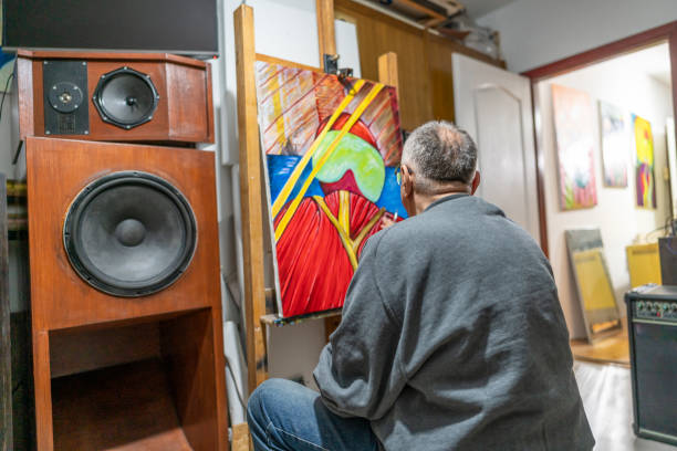 Senior creative professional painting an artwork in his home art studio
