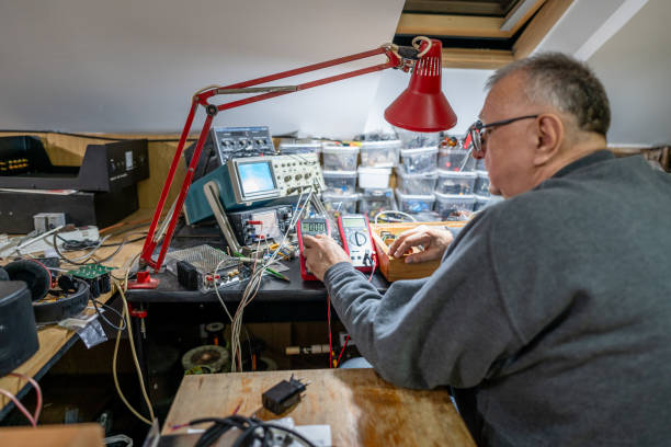 Senior man repairing electrical equipment at home
