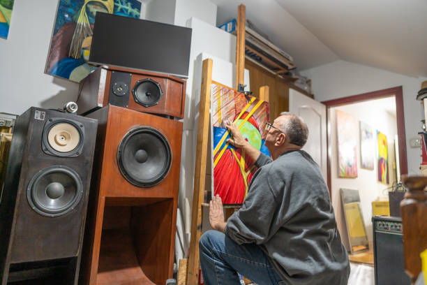 Senior creative professional painting an artwork in his home art studio