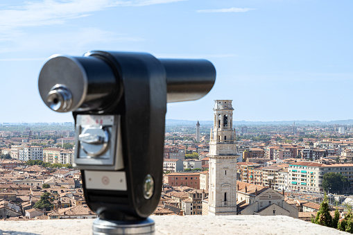 Beautiful view of Verona city from the top of Colle San Pietro (Saint Peter's Hill) with a defocused coin operated telescope in foreground; Veneto, Italy