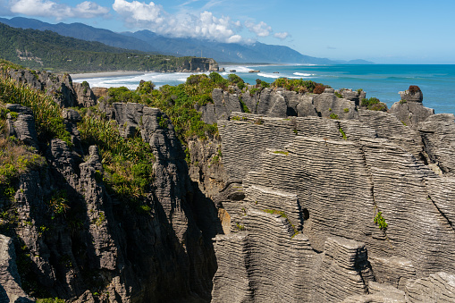 Uitzicht over de pancake rocks en blowholes van Punakaiki met op de achtergrond de kustlijn van Punakaiki