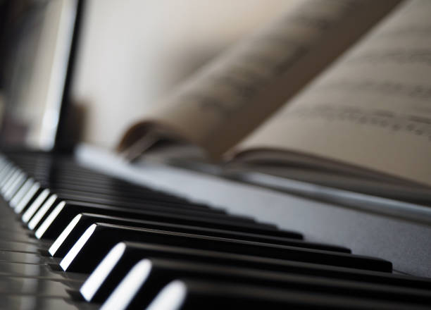 Piano keys and blurred sheet in paper with music notes. Musical notes on piano