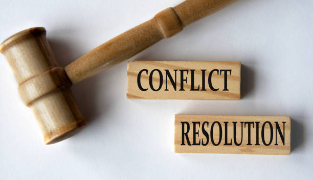 istock CONFLICT RESOLUTION - words on wooden blocks on a white background with a judge's gavel. 2043808581
