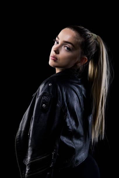 A woman dressed in a black leather jacket and leggings