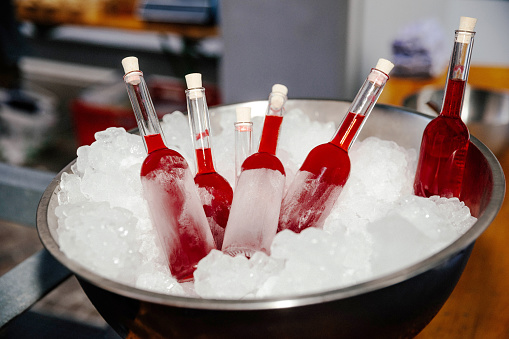 Red homemade popsicles stored in ice to stay chilled