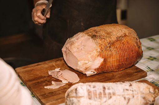 Close-up of a chef carving thin slices off a ham