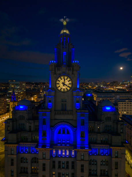 der wunderschön beleuchtete uhrenturm des lebergebäudes und der mythische lebervogel in der abenddämmerung - liverpool royal liver building clock tower building exterior stock-fotos und bilder