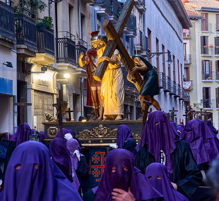 Pamplona, Spain, April 7, 2023: Religious Procession with Purple Robed Figures and Elaborate Float