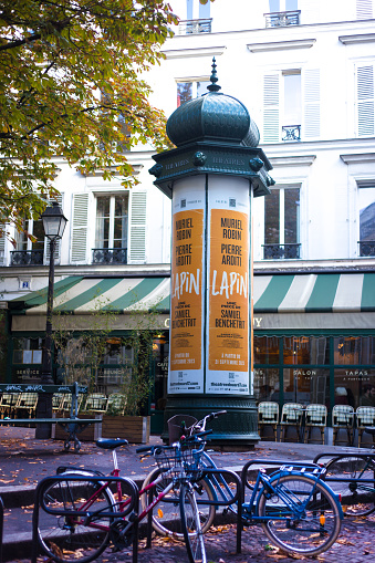 Paris, France: An old-fashioned advertising column plastered with ads for a theater performance called “Lapin” in the 9th arrondissement.