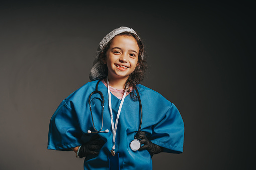 Confident Hispanic woman healthcare worker wearing dark blue scrubs wearing a stethoscope standing on white