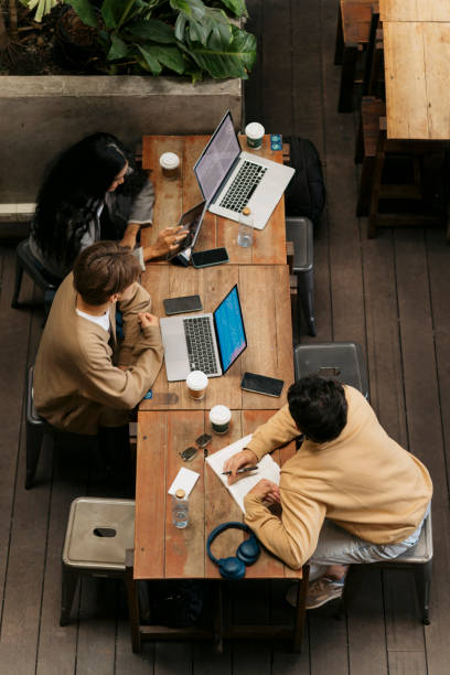 istock Diverse group of friends sitting at coffee shop working on their college assignment 2043987341
