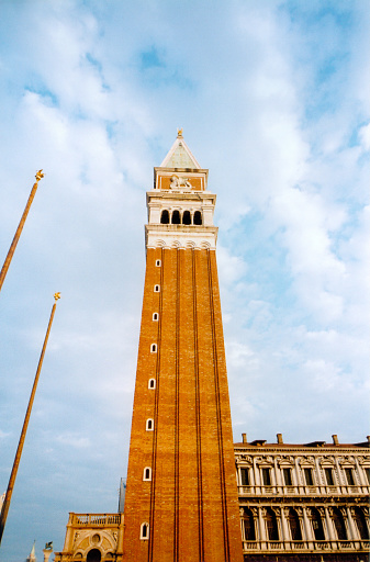 Venice, Veneto, Italy: looking up at St Mark's Campanile - the 98.5 meter high the bell tower of St Mark's Basilica in St. Mark's Square, the tower consists of a sturdy column of brick, a bell chamber with five bells, an observatory and a pyramid-shaped spire on which is a gilded weather vane depicting the archangel Gabriel.