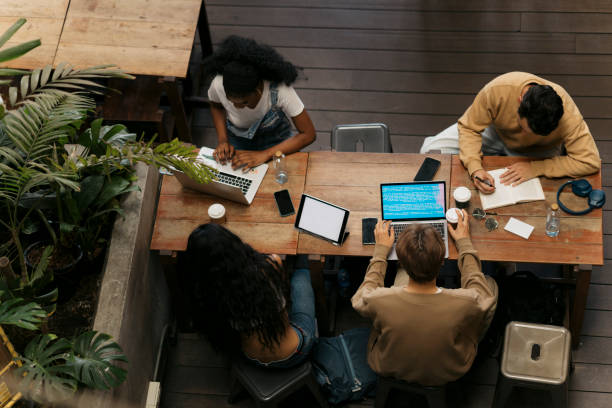 istock Friends sitting at cafe making notes on book and working on laptops 2043996991