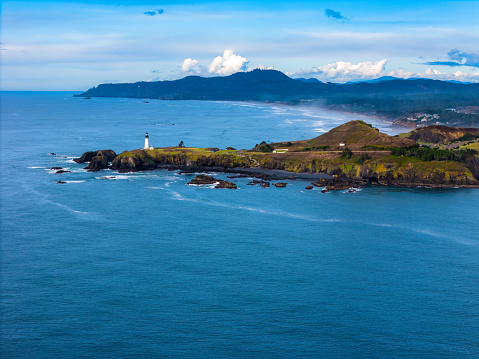Aerial oblique view of Yaquina Head Lighthouse with Cape Foulweather in background, located in Newport Oregon on the central coast.