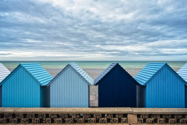 Blue beach huts, in water front on the beach in Dieppe, Normandy, France.