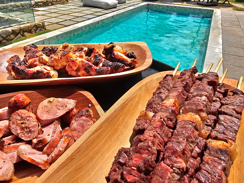 chicken, sausage and meat skewers being offered to guests