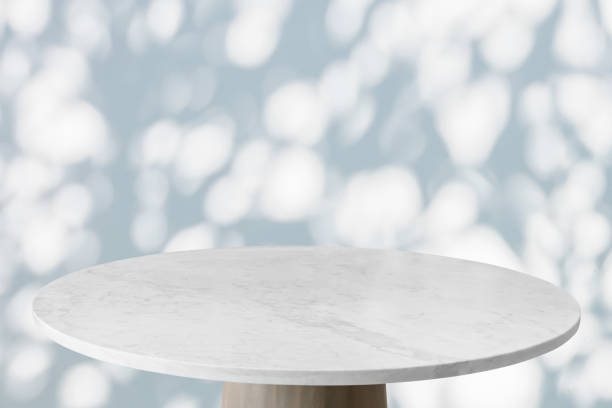 istock Round marble table top with tree leaves shadow drop on white wall background for mockup product display 2044064332