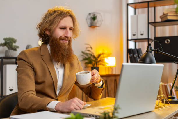 istock Businessman freelancer at home office table drinking morning coffee start working on laptop computer 2044072519