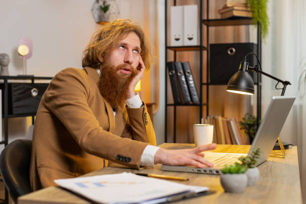 istock Bored sleepy tired businessman worker working on laptop computer leaning on hand at home office desk 2044073029