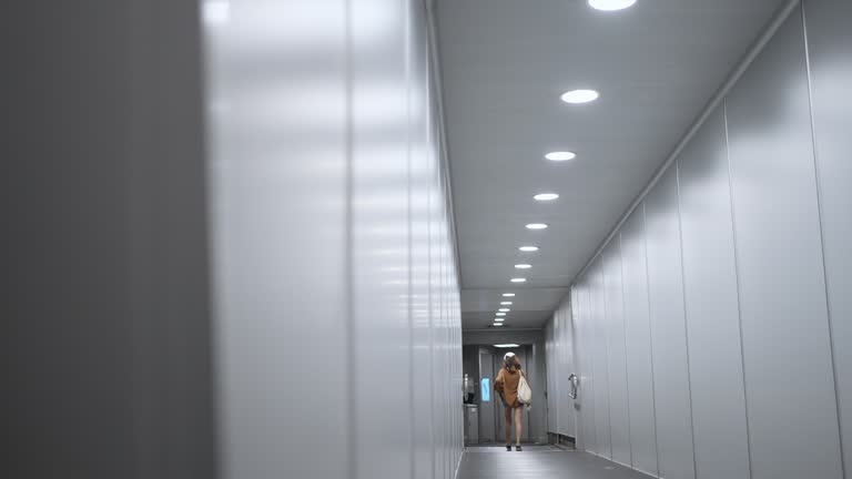 4K Asian woman walking down jet bridge into an airplane.