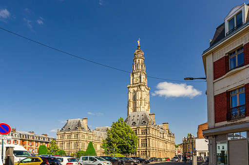 Arras, France, July 3, 2023: Hotel de Ville town hall building with belfry bell tower in historical city center, blue sky in summer day, Artois, Pas-de-Calais department, Hauts-de-France Region