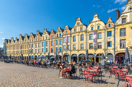 Arras, France, July 3, 2023: Flemish-Baroque-style townhouses buildings on market Heroes Square in historical city center, blue sky background, Artois, Pas-de-Calais department, Hauts-de-France