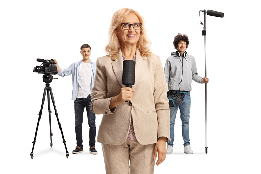 Female reporter with a microphone and boom and camera operators with recording equipment isolated on white background
