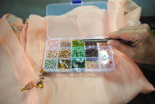 istock Hand is picking up colorful pearl beads. 2044210949