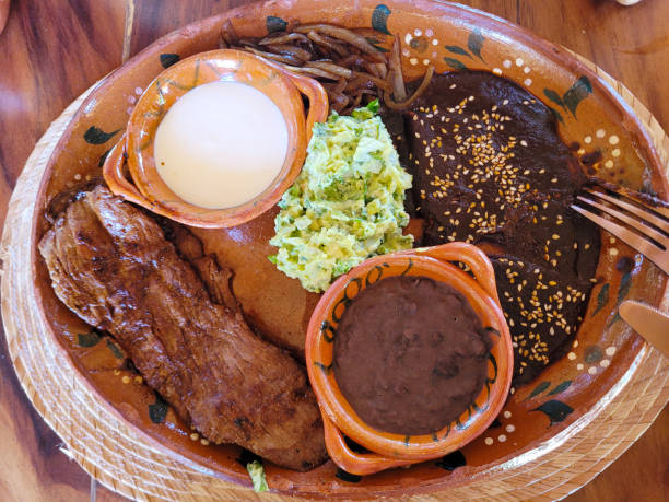 Authentic Mexican Tampiquena steak served with mole, beans, and guacamole