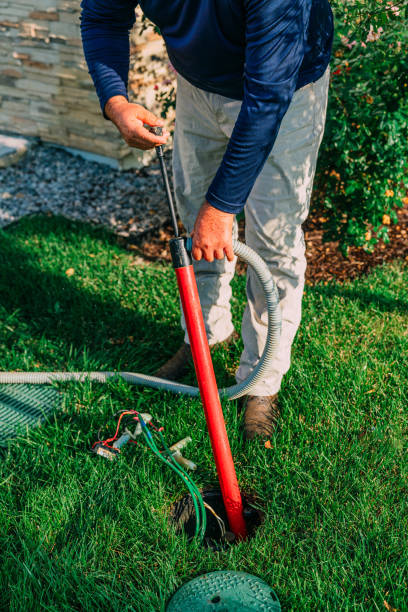 istock Man using a Hand Bilge Pump to Remove Water from a Flooded Sprinkler Wire Box 2044311613